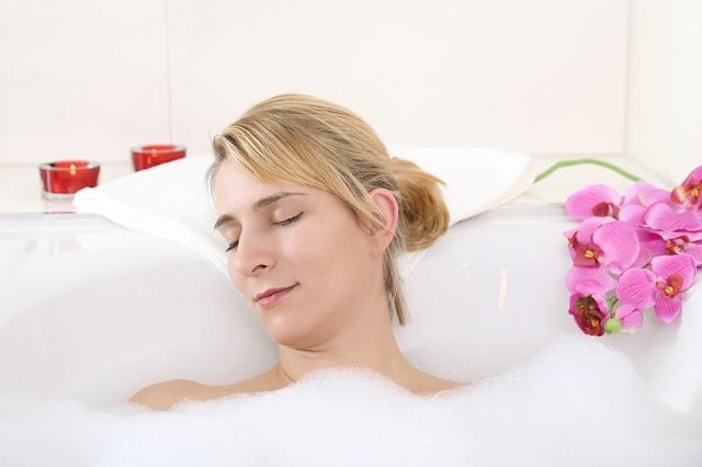 Frau nimmt ein entspannendes Bad im Rahmen einer Wärmetherapie.